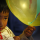 A Tibetan boy dressed in traditional attire holds a balloon as he observes the function organised to mark "Losar" or the Tibetan New Year at Tibetan Refugee Camp in Lalitpur February 19, 2015. REUTERS/Navesh Chitrakar